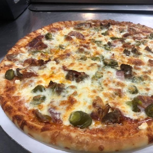 A freshly baked Backwoods Pizza with melted cheese, sausage, and green peppers.
